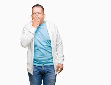 Orta yaş esneme izole arka plan üzerinde sweatshirt giyen Arap adam sıkılmış kapsayan ağız el ile yorgun. Restless ve uyku hali.