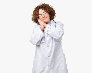 Orta ager kıdemli doktor kadın uyku yorgun hayal ve ellerle birlikte poz ile kapalı gözler gülümseyen izole arka plan.