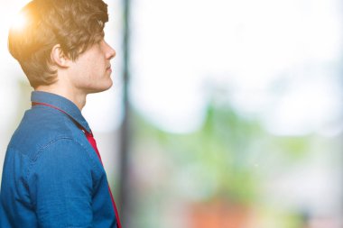 İzole arka tarafına, seyir üzerinde kırmızı kravat giyen genç yakışıklı iş adamı dinlenmek doğal yüz emin gülümseme ile pozuyla profili.