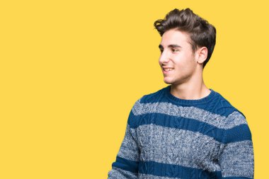 Yakışıklı delikanlı uzak tarafına yüzünde, doğal ifade gülümseme ile seyir izole arka plan üzerinde. Kendine güvenen gülüyor.