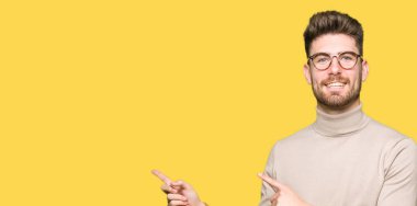 Gülümseyen ve iki elleri ve parmakları ile tarafına işaret kamera bakarak gözlüklü genç yakışıklı iş adamı.