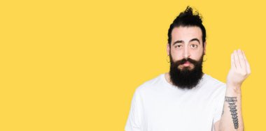 Uzun saç ve sakal casual Beyaz tişört yapıyor İtalyan giyen genç hipster adamla jest el ve parmak emin ifadesiyle