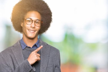 Gülümseyen ve iki elleri ve parmakları ile tarafına işaret kamera bakarak gözlüklü afro saçlı genç Afro-Amerikan iş adamı.
