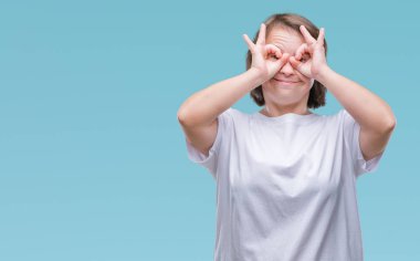 Genç Yetişkin kadın dilini, parmaklarının arasından baktığını yapışmasını dürbün gibi ok jest yapıyor izole arka plan üzerinde down sendromlu. Deli ifade.