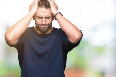 Genç yakışıklı adam kazak giyiyor çünkü umutsuz ve stresli baş ağrısı acı izole arka plan üzerinde ağrı ve migren. Ellerini kafasına.