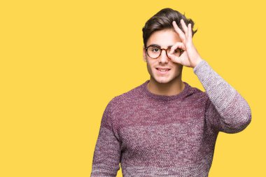 Gülümseyen, parmakları ile mutlu yüz üzerinden seyir göz el ile ok jest yapıyor izole arka plan üzerinde gözlük takan genç yakışıklı adam.