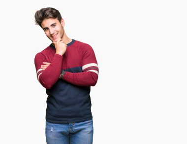 Yakışıklı delikanlı emin çapraz kollar ve çeneme kaldırdı el ile gülümseme ile kameraya bakarak izole arka plan üzerinde. Pozitif düşünce.