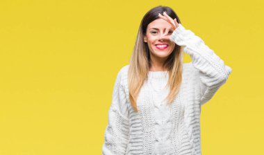 Genç güzel kadın rahat beyaz kazak gülümseyen, parmakları ile mutlu yüz üzerinden seyir göz el ile ok jest yapıyor izole arka plan üzerinde.