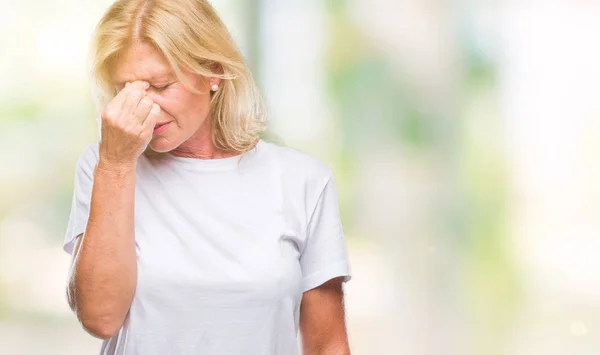 中年金发女人在孤立的背景下疲惫的摩擦鼻子和眼睛感到疲劳和头痛 压力和挫折概念 — 图库照片