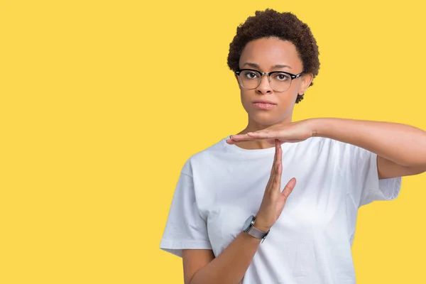 Beautiful young african american woman wearing glasses over isolated background Doing time out gesture with hands, frustrated and serious face