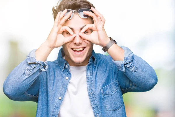 Jonge Knappe Man Dragen Van Een Zonnebril Geïsoleerde Achtergrond Doen — Stockfoto