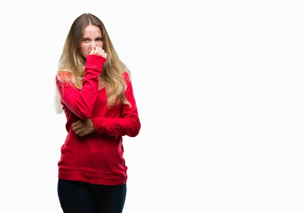 鼻に何か臭いと嫌な孤立した背景の臭いがする上の赤いセーター 耐え難い匂い 指で保持息を着た若い美しい金髪女性 悪いにおいの概念 — ストック写真