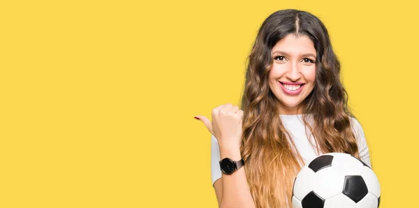 Joven Mujer Adulta Sosteniendo Pelota Fútbol Apuntando Mostrando Con Pulgar —  Fotos de Stock