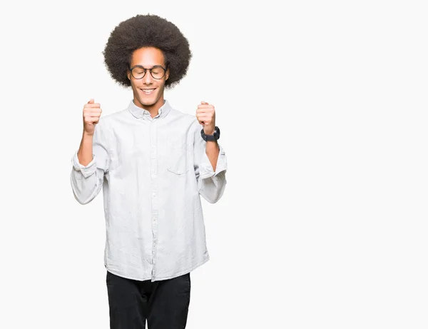 非洲青年美国男子戴着非洲头发戴着眼镜兴奋的成功与手臂举起庆祝胜利的微笑 优胜者概念 — 图库照片