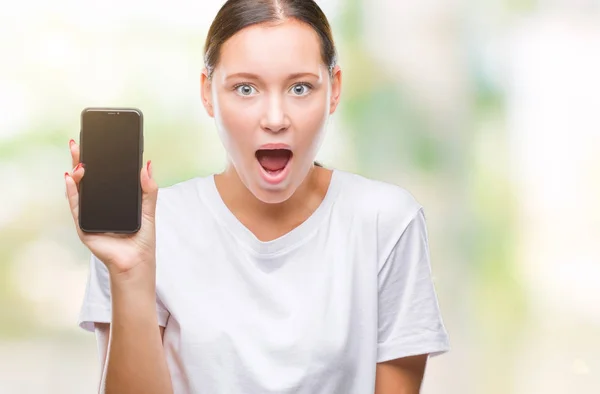 Young Beautiful Caucasian Woman Showing Smartphone Screen Isolated Background Scared — Stock Photo, Image