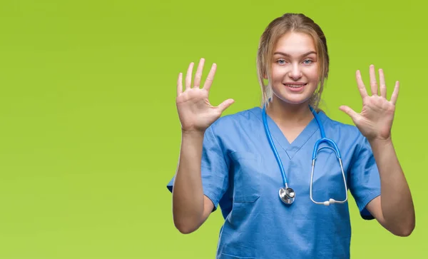 若い白人医師女性の外科医の制服を着て分離を示す背景と自信を持って 幸せな笑みを浮かべている間 番号を指で上向き — ストック写真