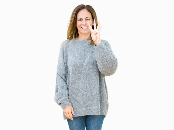 分離背景表示と指で上向きに美しい中年女性の身に着けている冬のセーター数は自信を持って 幸せな笑みを浮かべている間 — ストック写真