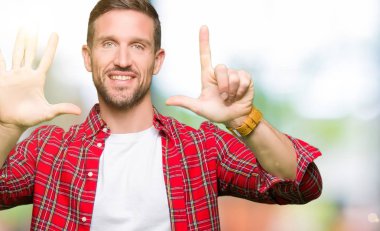 Gösterilen ve parmakları ile işaret rahat gömlek giymiş yakışıklı adam kendinden emin ve mutlu gülümseyerek süre yedi numara.