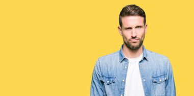 Denim ceket şüpheci ve sinir, papatyanın üzgün sorunu nedeniyle giyen sakal ve mavi gözlü yakışıklı adam. Negatif kişi.