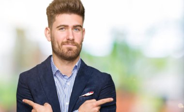 Genç yakışıklı bussines adam işaret parmakları ile her iki taraf için farklı yönde katılmıyorum