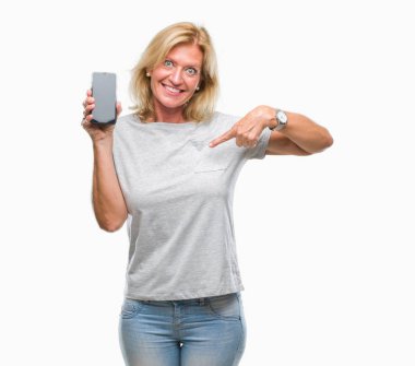 Orta yaş sarışın kadın gösteren boş ekran smartphone sürpriz yüz işaret parmağı kendini izole arka plan üzerinde