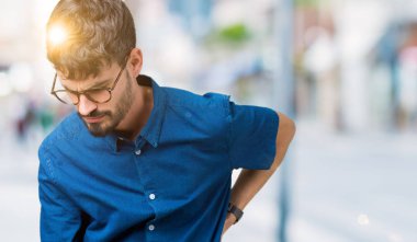 Genç yakışıklı adam gözlük izole üzerinde el ile geri, kas ağrısı dokunmadan acı sırt ağrısı, arka plan