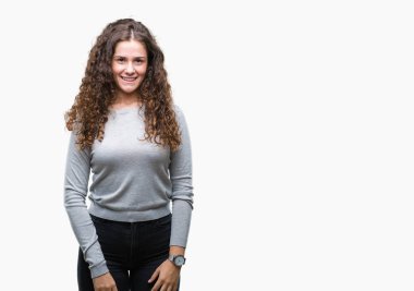 Güzel esmer kıvırcık saçlı Genç kız yüzünde mutlu ve güzel bir gülümseme ile izole arka plan üzerinde bir kazak giyiyor. Şanslı kişi.