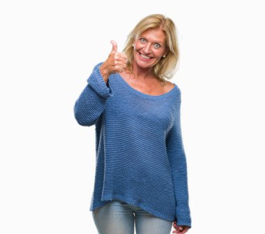 Orta yaş sarışın kadın hareketi el ile mutlu yaşasın yapıyor izole arka plan üzerinde kış kazak giyiyor. Kameraya bakarak başarı gösteren ile ifade onaylama.