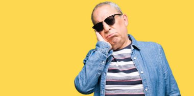 Denim ceket ve yorgun ve bıkkın ile depresyon sorun Çapraz kollar ile seyir düşünüyorum güneş gözlüğü takan yakışıklı komuta sizde.