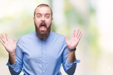 Genç beyaz hipster adam deli kutluyor arka plan izole ve başarı için kaldırdı kollarını açarak hayrete ve heyecanlı çığlık gözleri açık. Kazanan kavramı