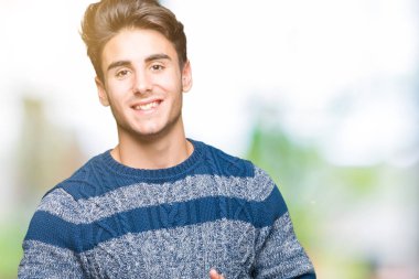 Genç yakışıklı adam arka plan eller birlikte izole ve rahat ve neşeli gülümseyen parmak çarpı işareti. Başarı ve iyimser