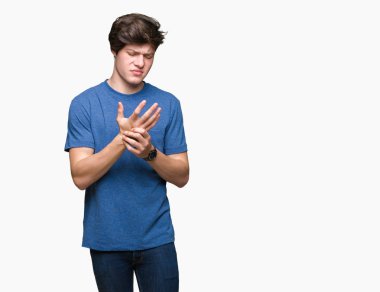 Elleri ve parmakları, artrit inflamasyon izole arka plan acı acı üzerinde mavi t-shirt giyen genç yakışıklı adam
