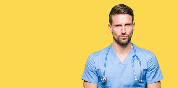 Hombre Guapo Doctor Vistiendo Uniforme Médico Sobre Fondo Aislado Escéptico — Foto de Stock