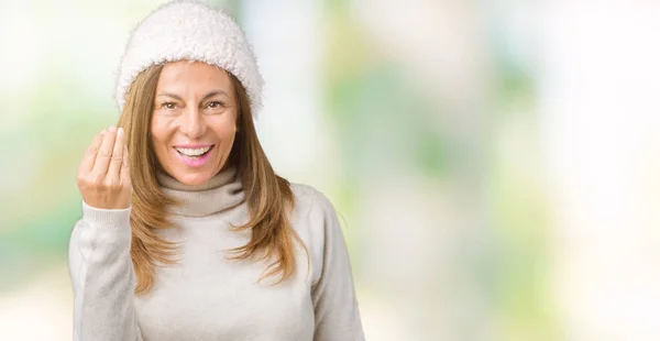 Beautiful middle age woman wearing winter sweater and hat over isolated background Doing Italian gesture with hand and fingers confident expression
