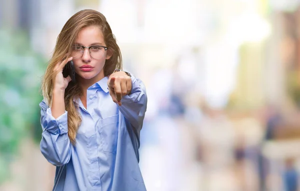 Young beautiful blonde business woman calling using smartphone over isolated background pointing with finger to the camera and to you, hand sign, positive and confident gesture from the front