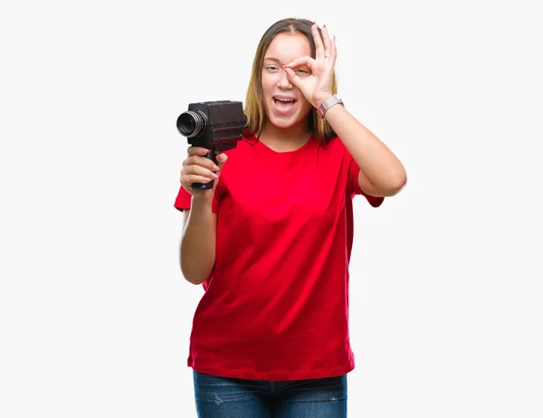 ビンテージ カメラを使った撮影若い美しい白人女性が指を通して見る目に手で サインをして笑っている幸せそうな顔で背景を分離 — ストック写真