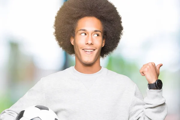 Молодий Афроамериканець Людиною Афро Волосся Тримаючи Футбольний Футбол Вказуючи Показуючи — стокове фото
