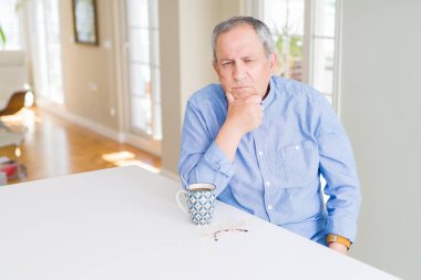 Üst düzey yakışıklı düşünme seyir yorgun ve çapraz kolları olan depresyon sorunları ile sıkılmış evde kahve içme.