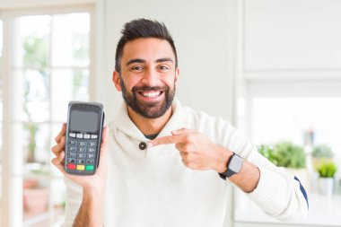 Nokta-in satış terminal dataphone çok mutlu el ve parmak ile işaret tutan Latin asıllı yakışıklı