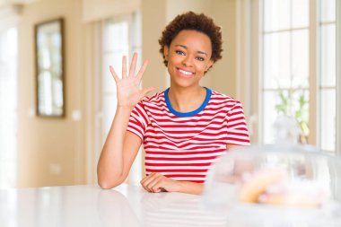 Genç güzel Afrikalı-Amerikalı kadın evde gösterilen ve parmak beşinci ile gülümseyen ise kendinden emin ve mutlu yukarı dönük.