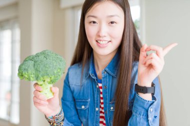 Yeşil taze brokoli el ve parmak ile tarafına işaret çok mutlu yemek güzel Asyalı kadın