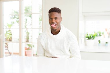 Afro-Amerikan yakışıklı beyaz masada dilini out komik ifade ile mutlu. Duygu kavramı.