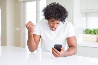 Afrika kökenli Amerikalı adam akıllı telefon kullanarak rahatsız ve boşa çıkarmak ile öfke, çılgın da yükseltilmiş el ile bağırmaya kavramı öfke