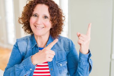 Gülümseyen ve iki ile işaret kamera bakıyor güzel kadın kıdemli eller ve yan parmak.