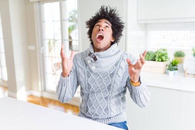 Afrikalı-Amerikalı adam kış kazak çılgın ve kızgın bağırarak ve agresif ifade ve silah kaldırdı bağırıyor. Hayal kırıklığı kavramı.