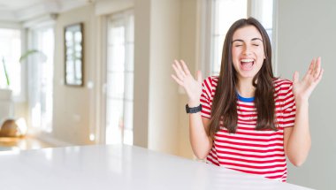 Casual çizgili kutluyor t-shirt kızgın ve silah ile başarı için deli giyen güzel genç kadın kaldırdı ve heyecanlı çığlık gözler kapalı. Kazanan kavramı