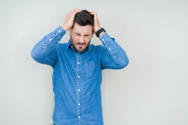 Yakışıklı delikanlı çünkü umutsuz ve stresli baş ağrısı acı izole arka plan üzerinde ağrı ve migren. Ellerini kafasına.