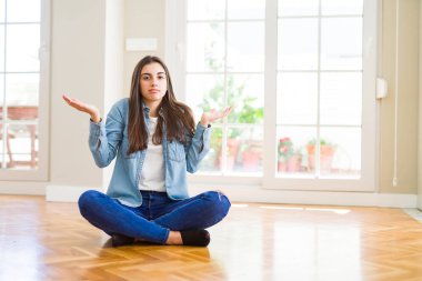 Ev clueless ve şaşkın bir ifadeyle kollar ve eller kaldırdı katta oturan güzel genç kadın. Şüphe kavramı.