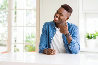 Evde yakışıklı Afro-Amerikan hareketi el ile mutlu Yaşasın yapıyor. Başarı gösteren kameraya bakarak ifade onaylama.