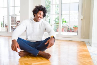 Afrika kökenli Amerikalı adam evde katta oturan uzak tarafına yüzünde, doğal ifade gülümseme ile arıyorum. Kendine güvenen gülüyor.